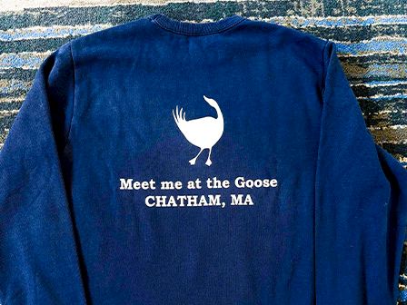 A navy blue shirt displaying a white goose and the text 